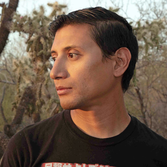Pablo in profile facing to his right, short brown hair, black T-shirt