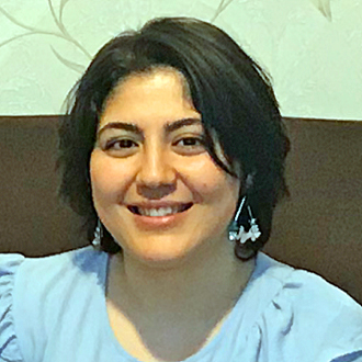 Nouri Soula facing forward smiling, short dark hair, blue shirt.