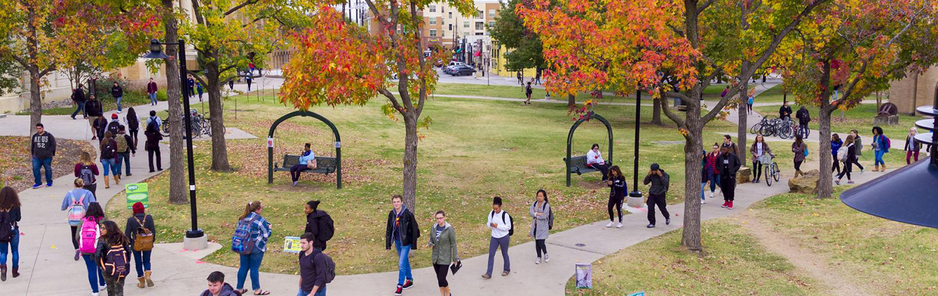 Fall day on campus, students walking on sidewalks.