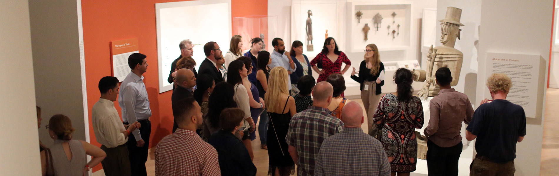 A group of people listening to a museum tour guide.