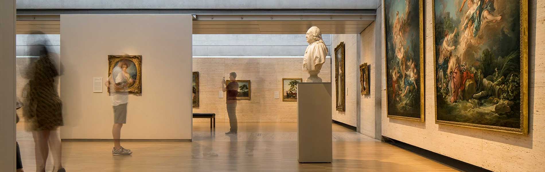 Interior gallery at the Kimbell Museum with walls of mounted paintings.