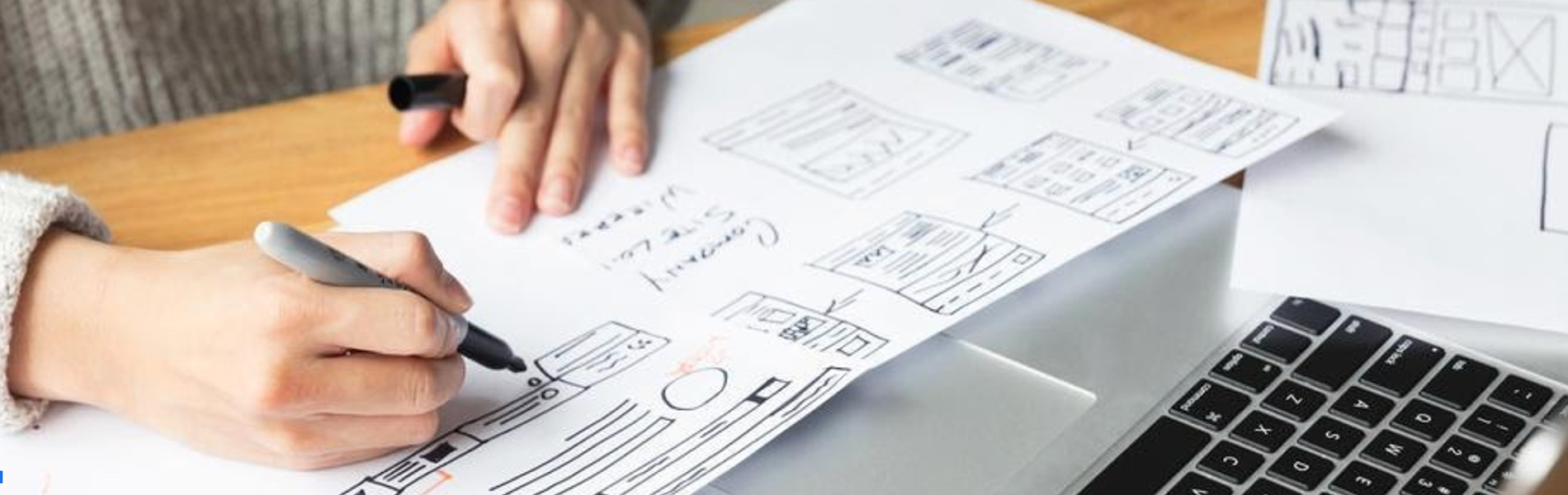 Hands shown drawing a schematic for user-experience design,