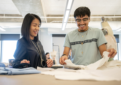 Chanjuan Chen with student Johnathan De la Cruz at the sewing table