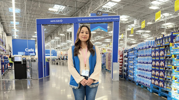 Woman standing in a shopping aisle at a Sam's Club store.