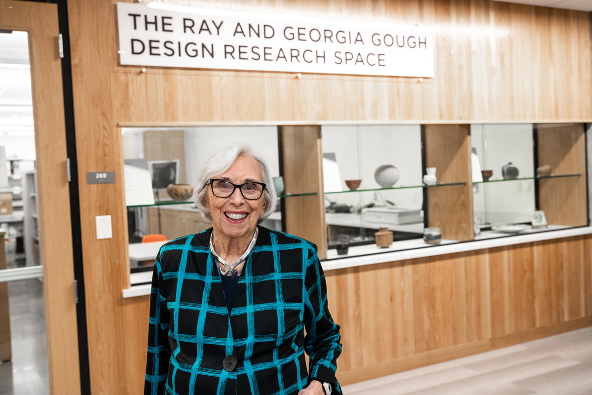 George Billie Gough standing in front of the door to the Ray and Georgia Gough Design Research Center.