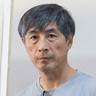 Stephen Zhang facing forward. He has dark hair and wears a blue shirt.