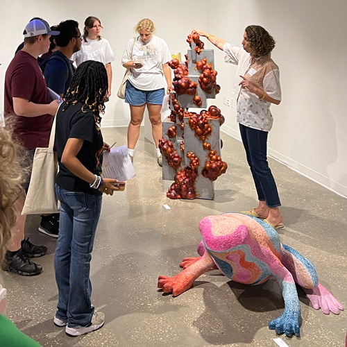 Alicia Eggert showing a sculpture to students.