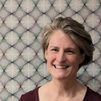 Amie Adelman smiling, short hair, maroon top