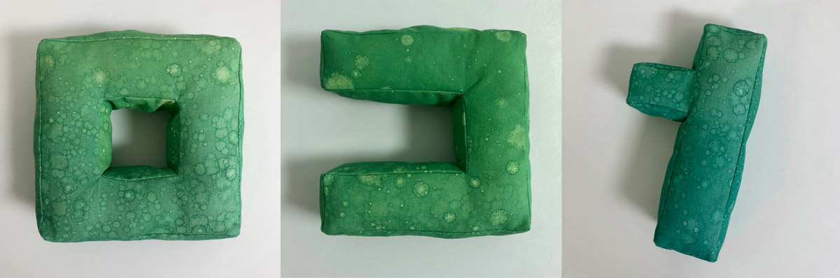 Pillow forms made from fabric printed with multiple layers of green ink.