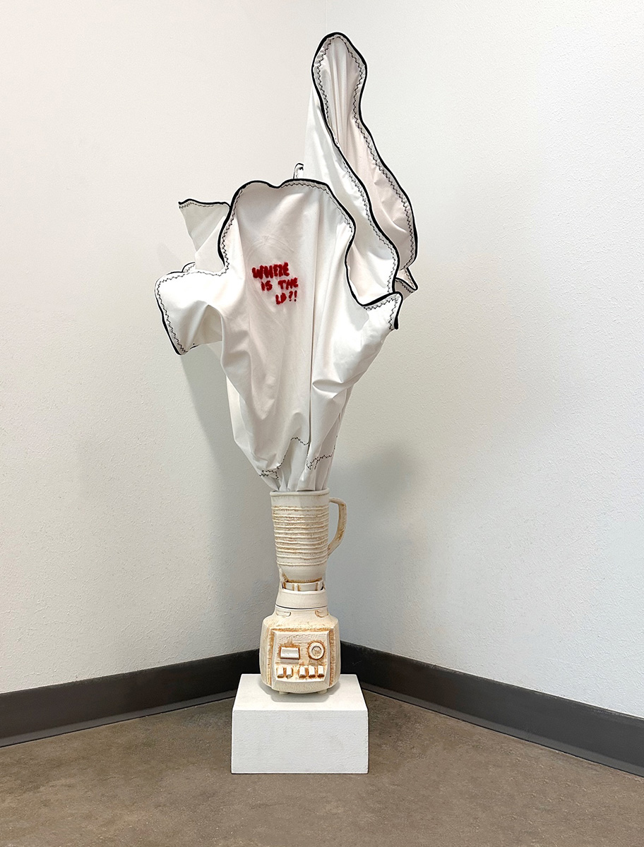 White ceramic sculpture of a blender spewing white liquid made of fabric from its top.