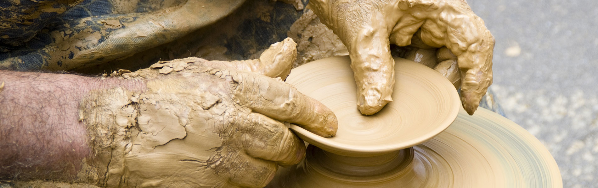 Hands in wet clay at the potter's wheel