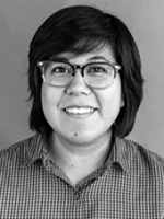 Laura smiling at the camera, black-and-white head and shoulders, short hair, wearing glasses