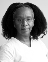 Leticia Huckaby, looking at the camera, long dark hair, wearing glasses, black-and-white photo