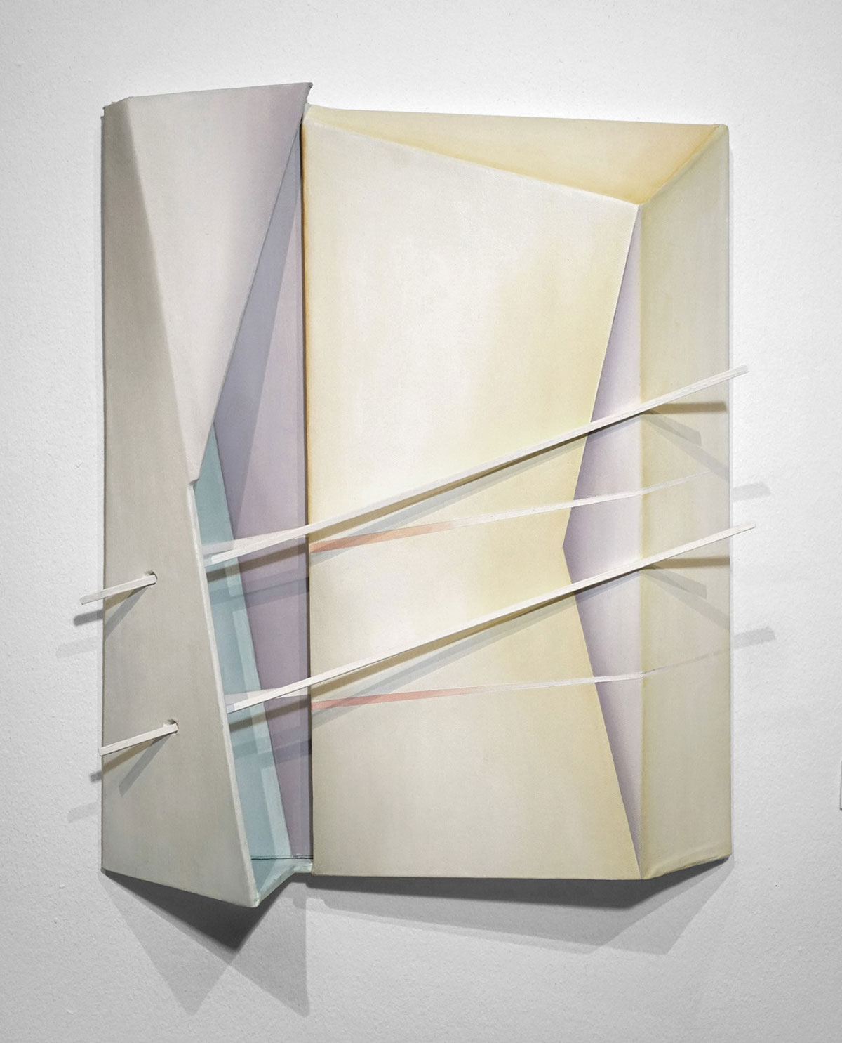 A vertical, 3D sculptural artwork with white, green, purple, and yellow intersecting geometric shapes.