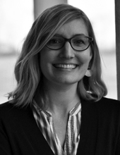 Beth Link, shoulder-length hair, glasses, smiling a the camera, head-and-shoulders portrait