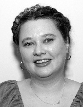 Ailie smiling at the camera, black-and-white photo of head and shoulders