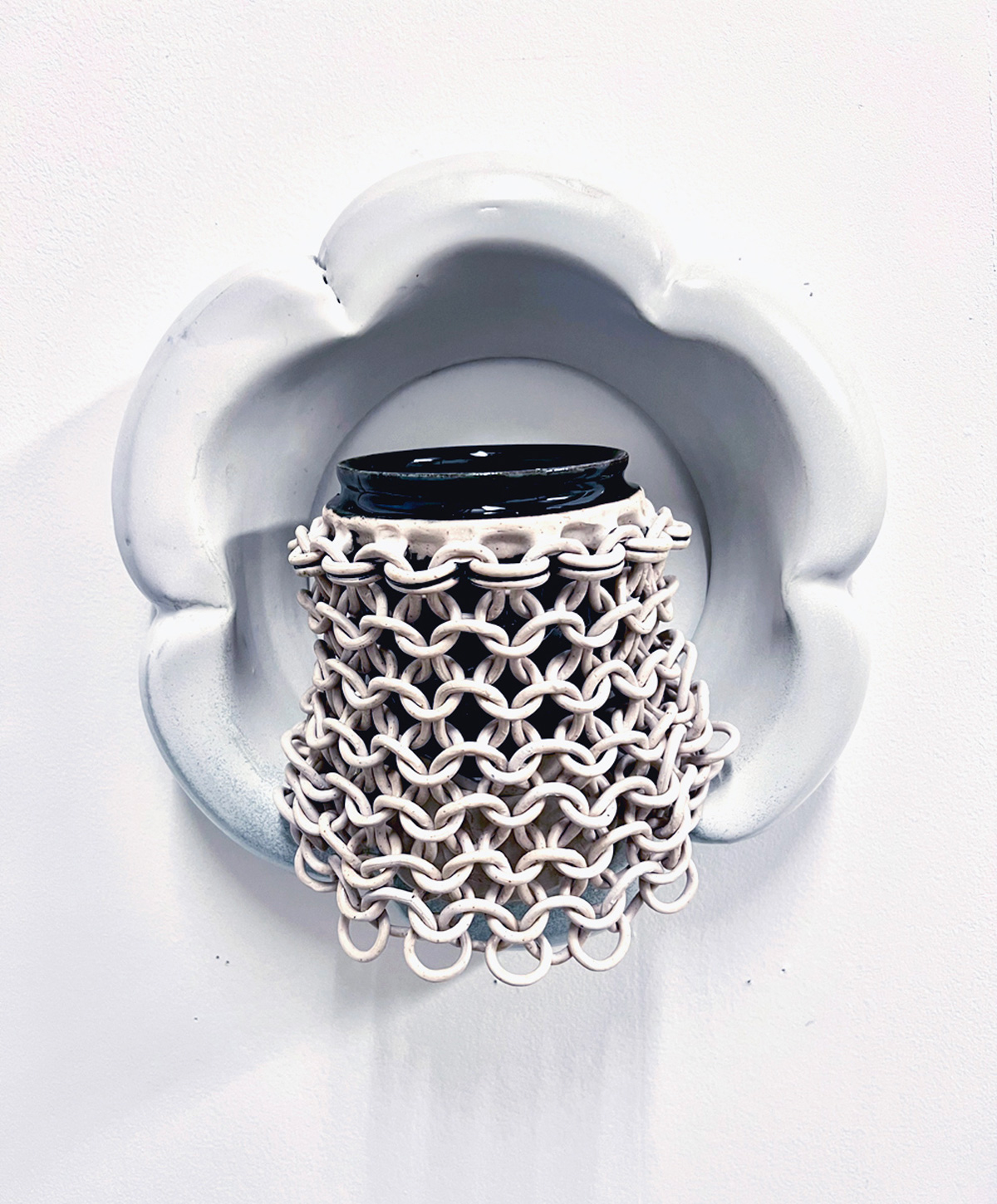A white cup surrounded by a veil of malleable rings. 