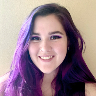 Courtney smiling at the camera, purple and dark brown long hair
